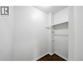 A white interior space with a shelf and a wooden floor.