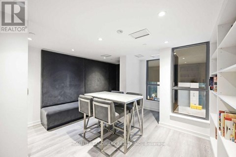 A modern dining room with a dark grey sofa and a glass display cabinet.