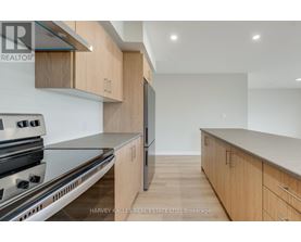 A modern kitchen with wooden cabinets and stainless steel appliances.