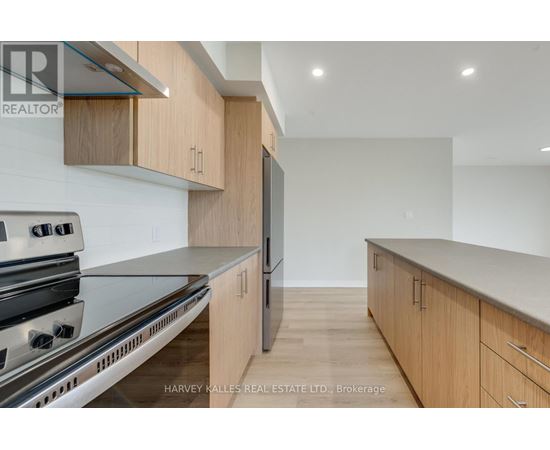 A modern kitchen with wooden cabinets and stainless steel appliances.