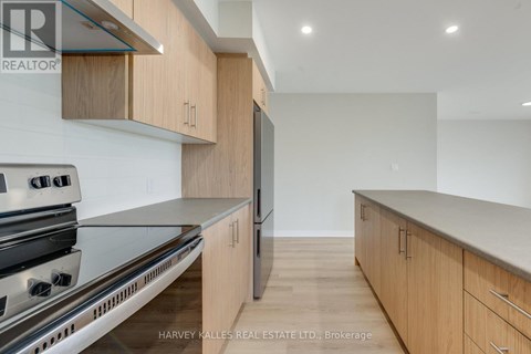 A modern kitchen with wooden cabinets and stainless steel appliances.