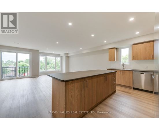 A spacious kitchen with wooden cabinets and a large island.