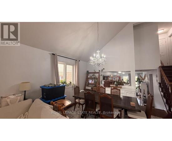 A well-lit dining area with a chandelier and a table set for six.