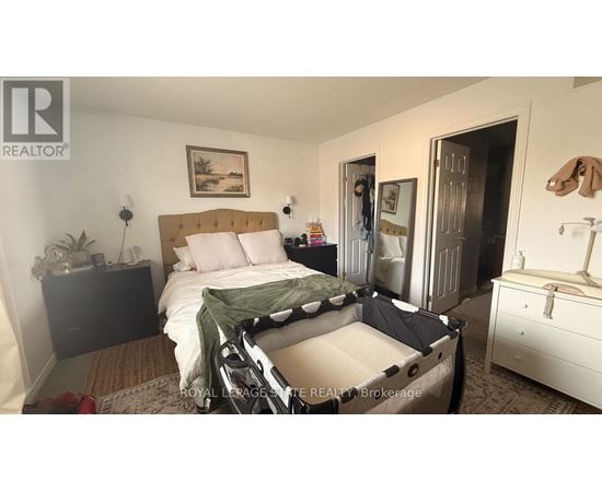 A bedroom with a bed, dresser, and mirror.