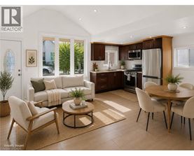 A modern living room with a dining area and a kitchen in the background.
