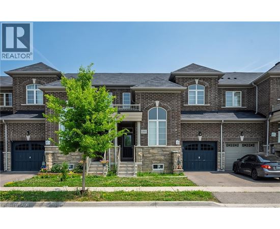 A large, multi-story house with a stone facade and a garage.