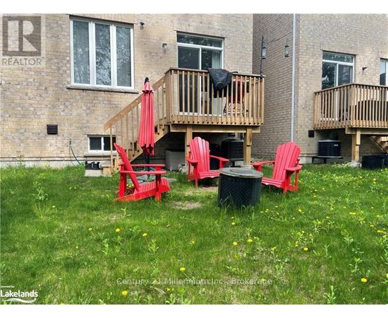 A red chair and table are set up on a lawn in front of a building.