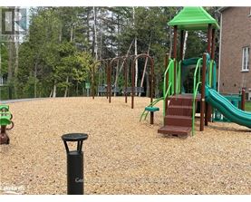 A playground with a green slide and a brown wooden structure.