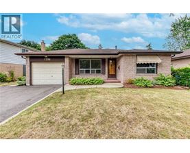 A house with a brown roof and a white garage door is for sale.
