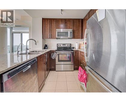 A kitchen with a stainless steel refrigerator and wooden cabinets.