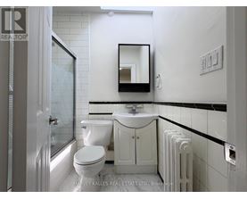 A white bathroom with a toilet, sink, and mirror.