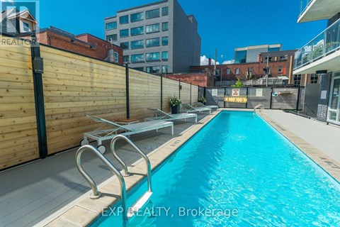 A pool surrounded by a wooden fence and a metal railing.