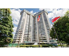 A tall building with a fence in front of it and two flags on top.