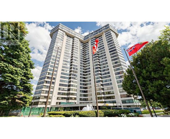 A tall building with a fence in front of it and two flags on top.