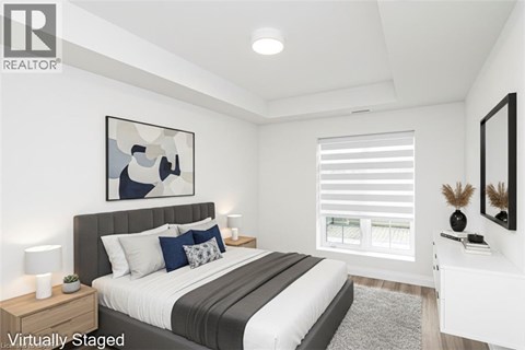 A bedroom with a large bed and a painting on the wall.