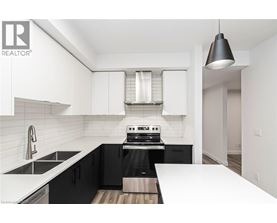 A modern kitchen with black cabinets and white countertops.