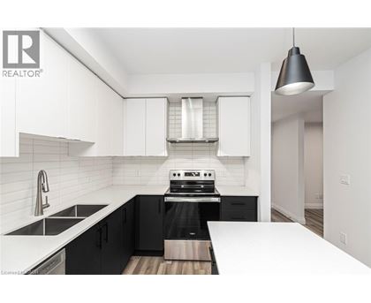 A modern kitchen with black cabinets and white countertops.