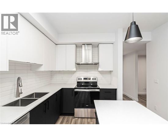 A modern kitchen with black cabinets and white countertops.