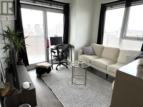 A living room with a couch, chair, and a table with a glass on it.