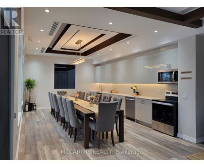 A modern dining room with a long table and chairs.