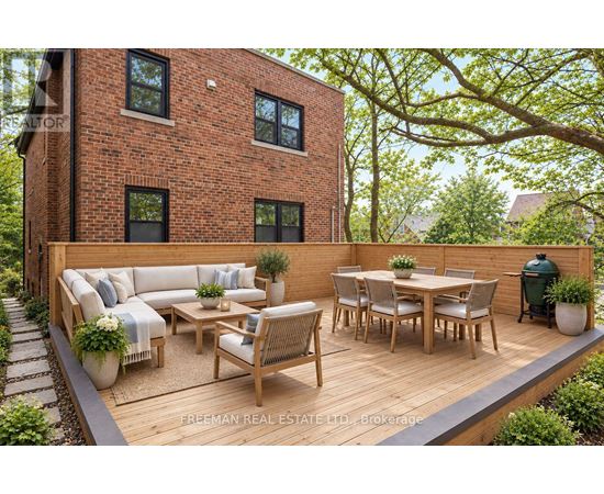 A wooden deck with a table and chairs is in front of a brick building.