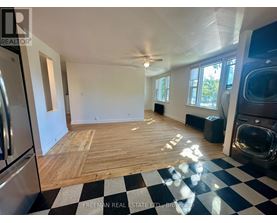 A large empty room with wooden flooring and a checkered floor.