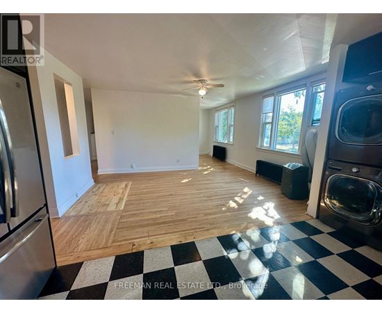A large empty room with wooden flooring and a checkered floor.