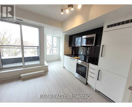 A modern kitchen with white cabinets and stainless steel appliances.