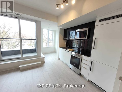 A modern kitchen with white cabinets and stainless steel appliances.
