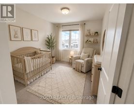 A well-lit nursery room with a crib, a chair, and a small tree.