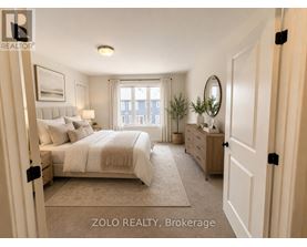 A well-lit bedroom with a large bed, a dresser, and a mirror.