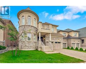A large, luxurious house with a stone tower and a well-manicured lawn.