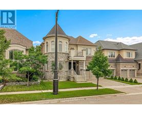 A large, well-maintained house with a stone pillar in the front yard.