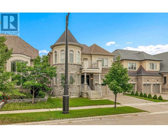 A large, well-maintained house with a stone pillar in the front yard.