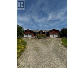 A house with a gravel driveway in front of it.