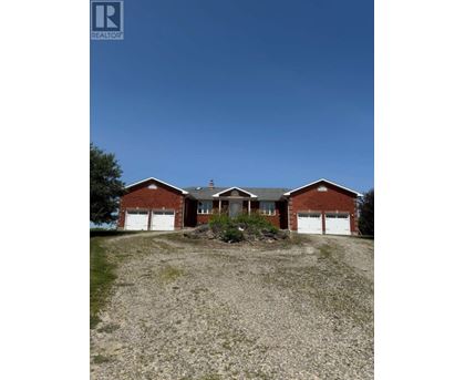 A house with a gravel driveway in front of it.