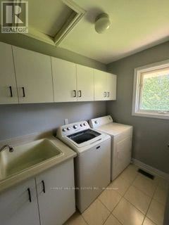 A small kitchen with a sink, stove, and cabinets.