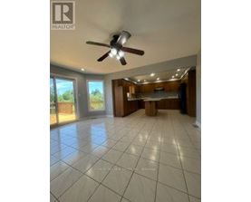 A spacious room with a ceiling fan and tiled flooring.