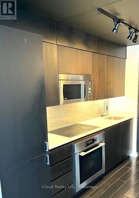 A modern kitchen with a stainless steel oven and microwave.