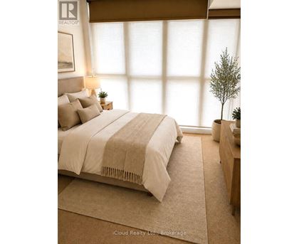 A bedroom with a large bed and a small tree on the nightstand.