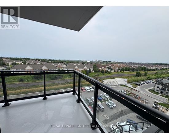 A balcony with a view of a parking lot and buildings.