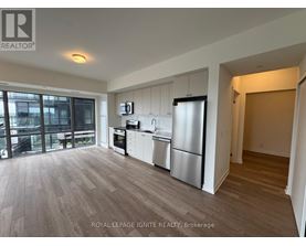 A kitchen with a refrigerator, oven, and microwave.