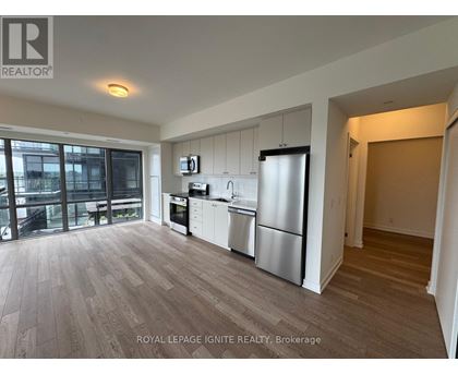 A kitchen with a refrigerator, oven, and microwave.
