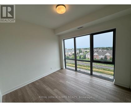 A room with a large window overlooking a residential area.