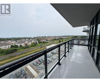 A balcony with a view of a parking lot and buildings.