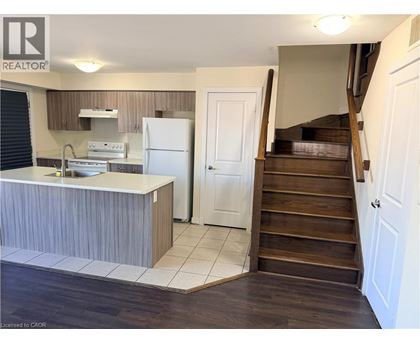 A kitchen with a refrigerator, sink, and stove.