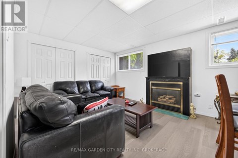A living room with a black couch and a fireplace.