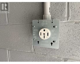 A wall socket with a key slot and a key inserted.