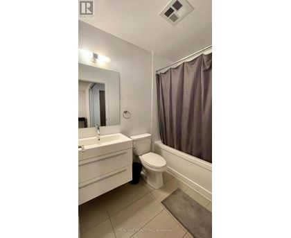 A bathroom with a toilet, sink, and bathtub.