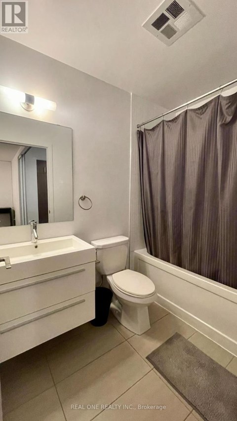 A bathroom with a toilet, sink, and bathtub.